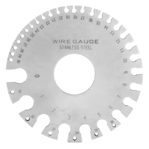 Circular stainless steel wire gauge with numbered outer slots and a central hole.