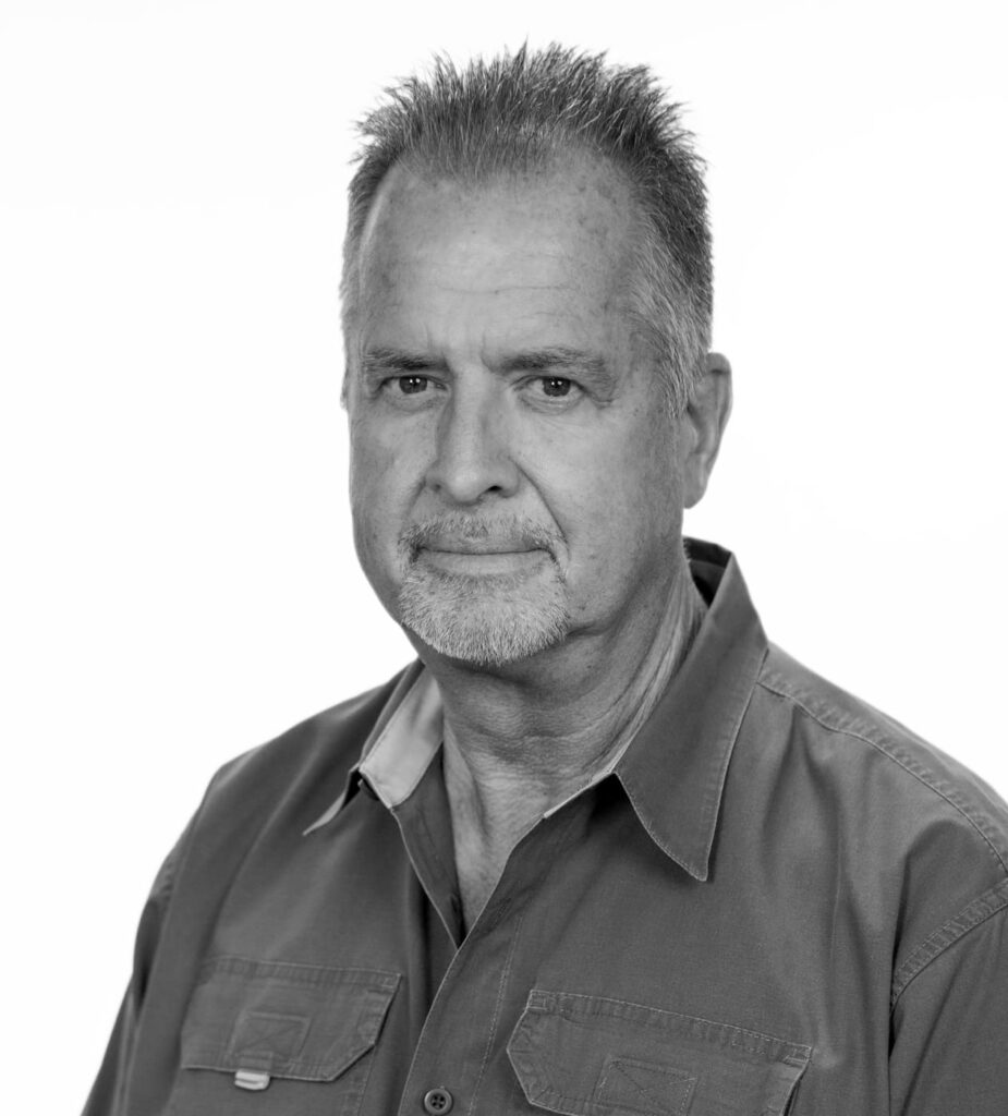 Black-and-white portrait of a middle-aged man with short gray hair wearing a collared shirt.