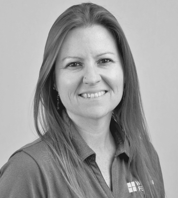Portrait of a smiling woman with long hair wearing a polo shirt.